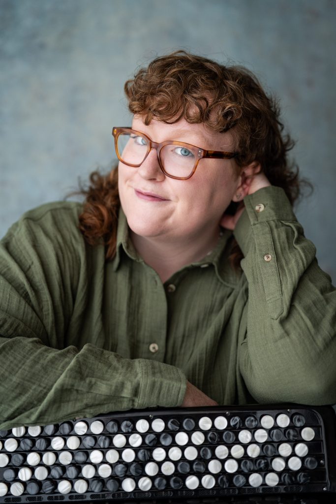 London-based accordion payer Aine McLoughlin in a green shirt - professional head shot
